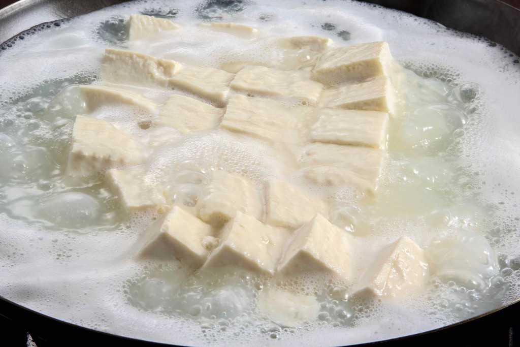煮立った鍋の中の湯豆腐、佐嘉平川屋の温泉湯豆腐を茹でる