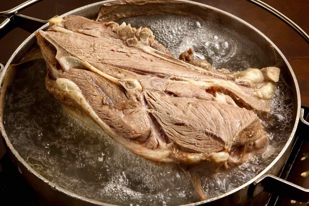鍋の中で大きなラム肉の塊を煮込む、モンゴルの羊肉の塩茹で料理、東洋肉店のチャンスンマハ
