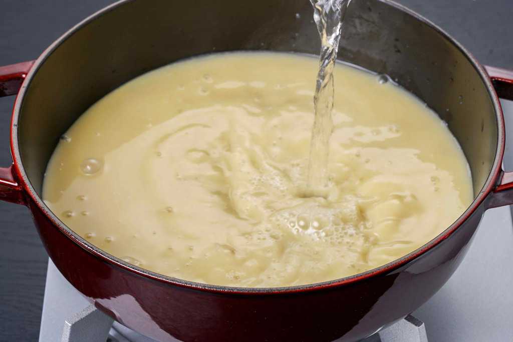 もつ鍋のスープにお湯を入れる、博多もつ鍋蟻月の白のもつ鍋のスープ