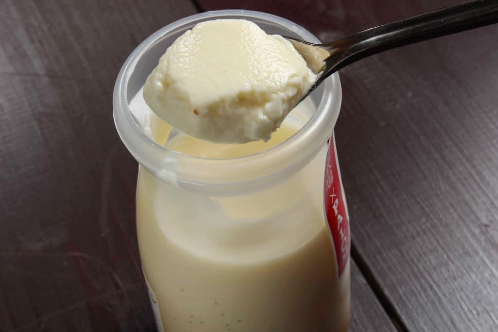 札幌スイーツガーデン「パロム」の斉藤牧場牛乳プリンをスプーンですくう