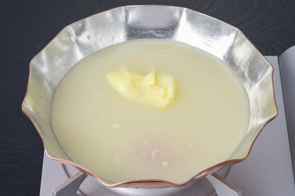 コンロの上の銅鍋に入った博多とり田の水炊き用スープ