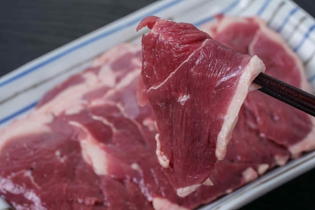 鴨重の合鴨ローススライス肉を箸で持つ、倭鴨のローススライス肉を箸で持つ