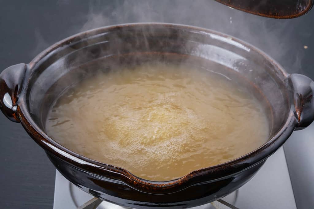 土鍋の中で煮立ったかしわの川中の地鶏スープ