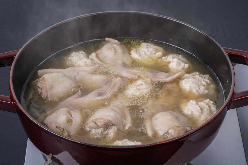 ストウブ鍋の中で煮込む手羽餃子とつみれミンチ